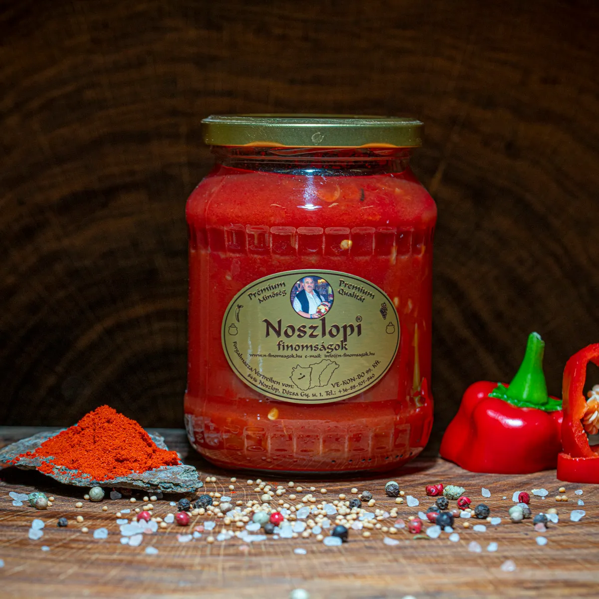 Noszlopi ungarisches Letscho im Glas mit Paprika Deko auf einer Holzplatte.