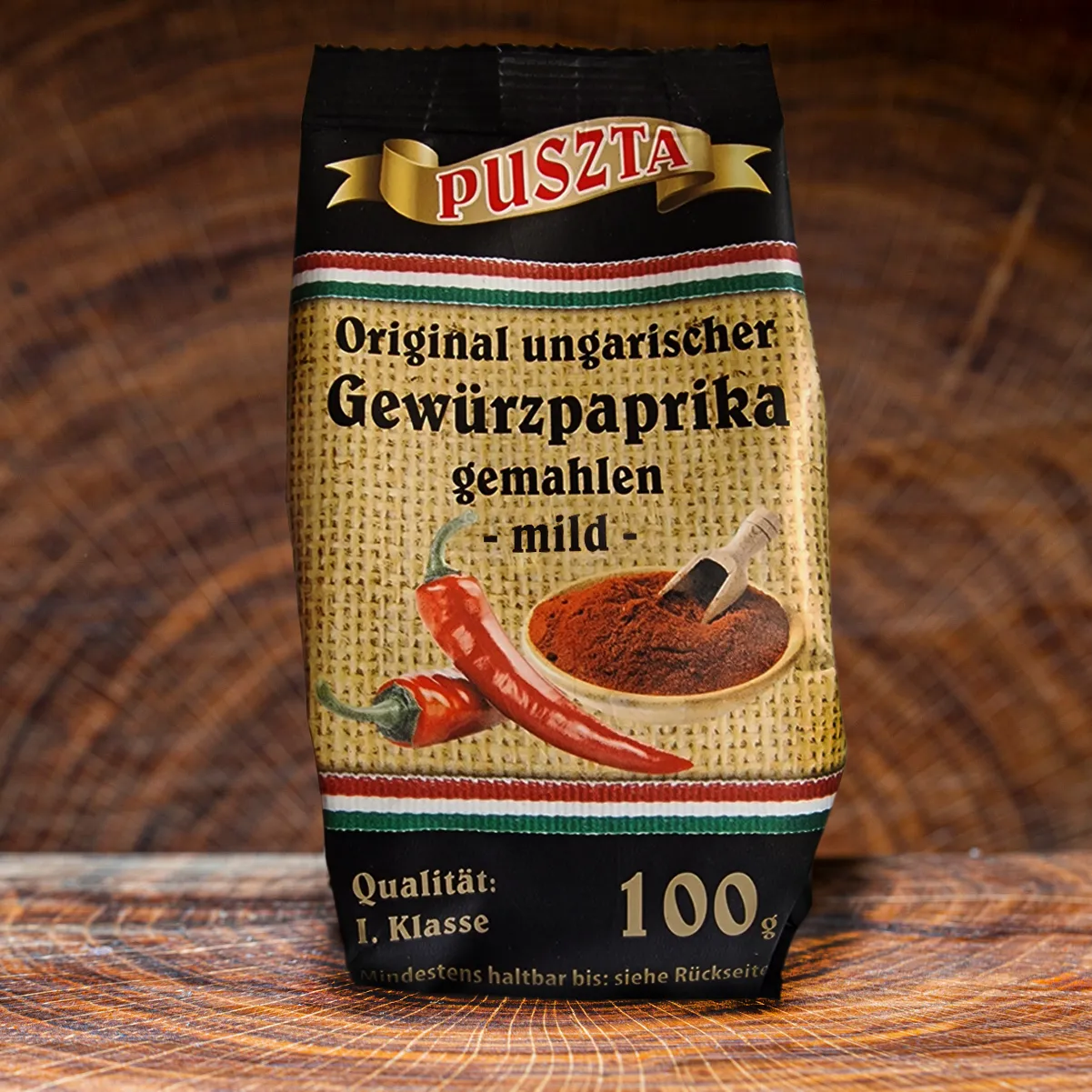 Puszta ungarischer Gewuerzpaprika Pulver mild auf einem Holzbrett.