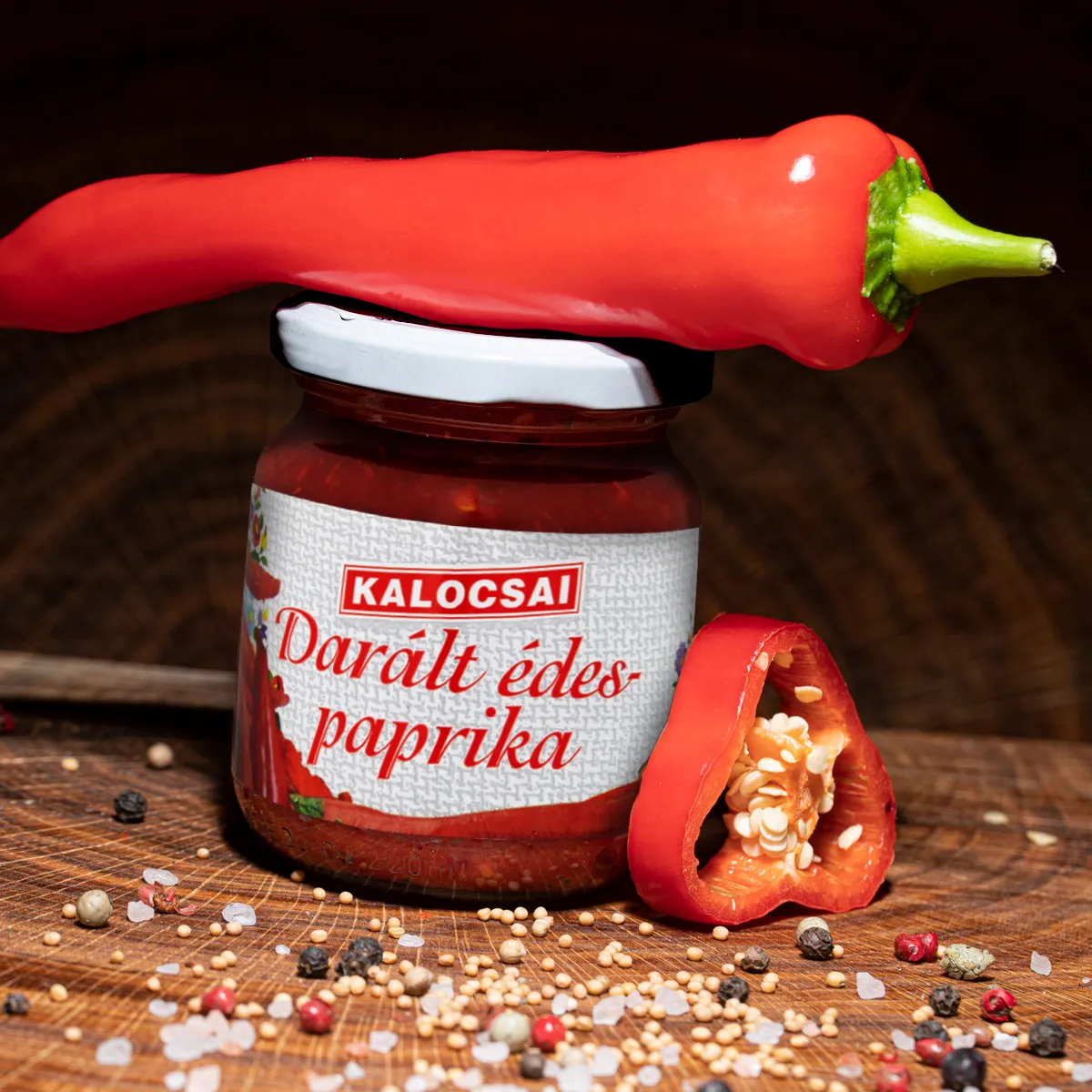 Kalocsai ungarisches Paprikapuerree mild im Glas mit Deko auf Holzbrett.