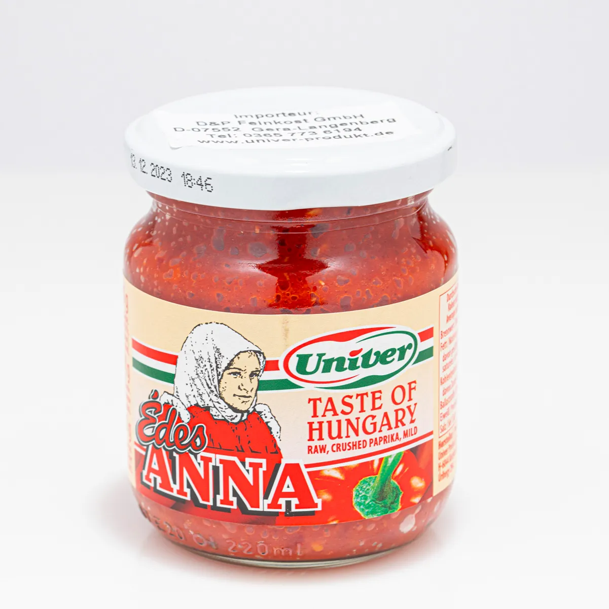Ungarische Paprikacreme "süße Anna" mit einer Chilischote auf weißem Hintergrund.