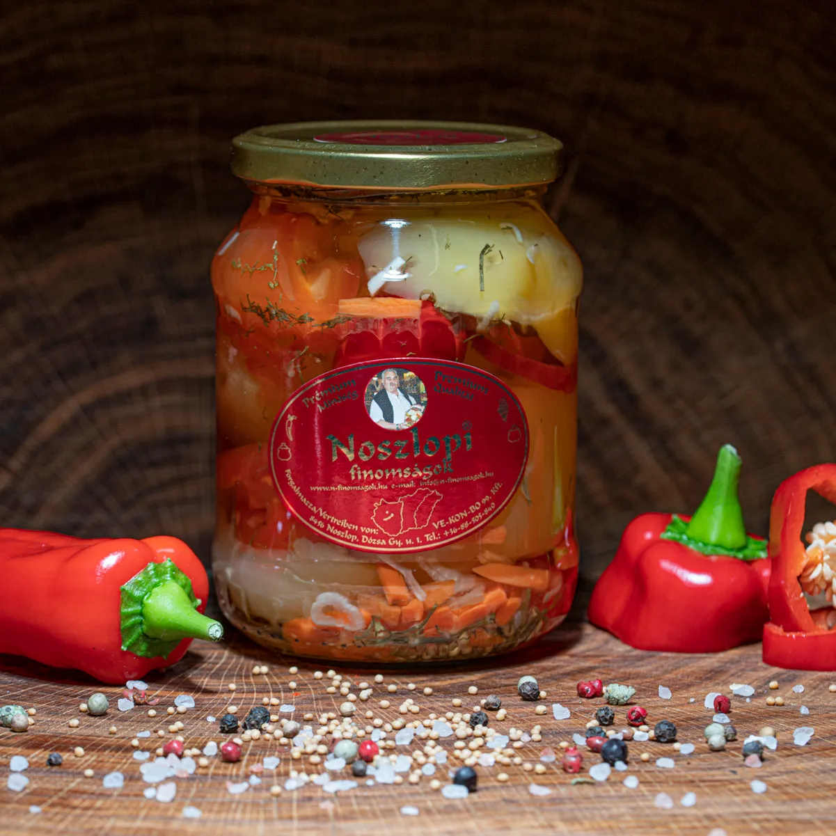 Noszlopi ungarisches Apfelpaprika in scharf im Glas mit Paprika Deko auf Holzbrett.