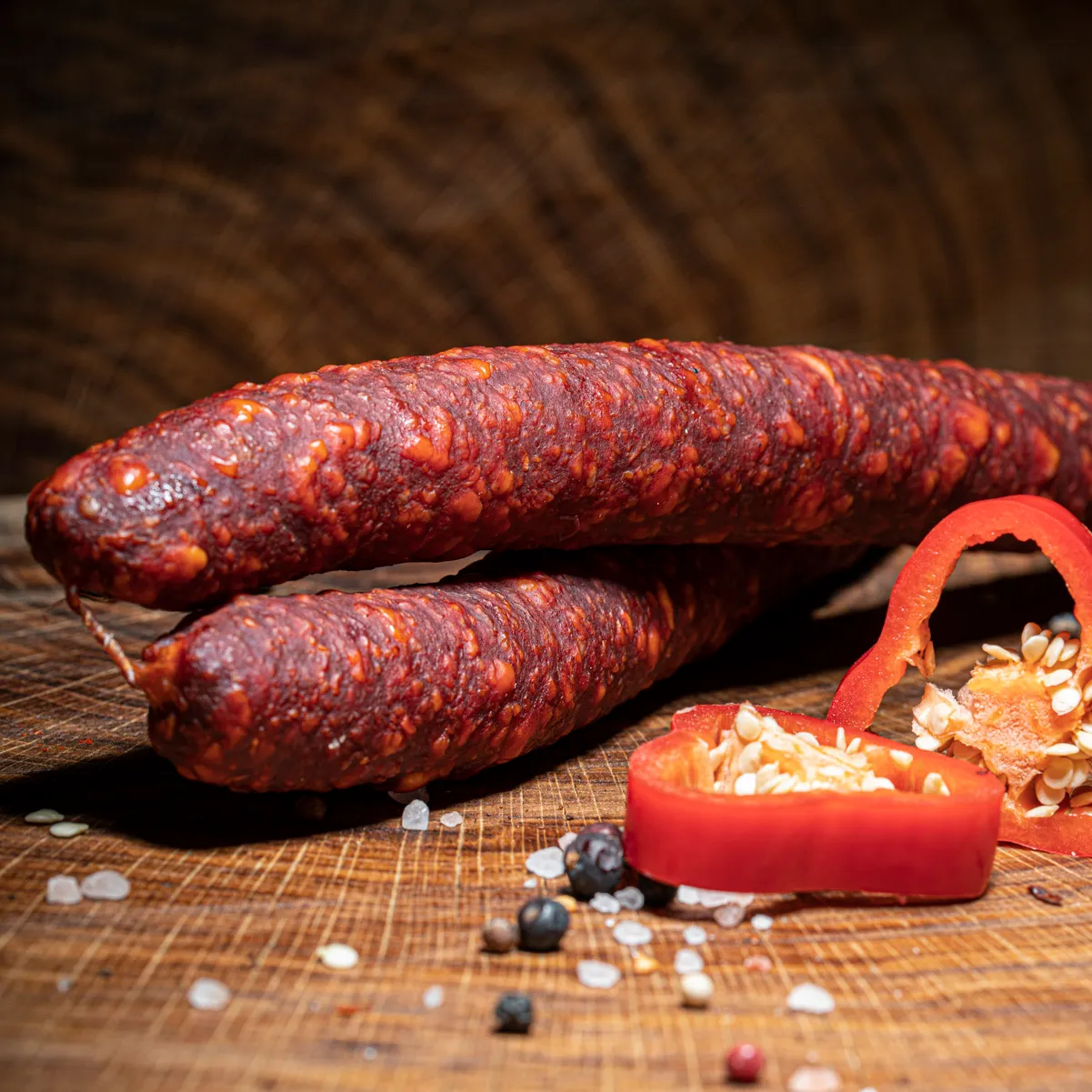 Ungarische Wurst Langolt-Kolbasz mit Deko auf Tischplatte.