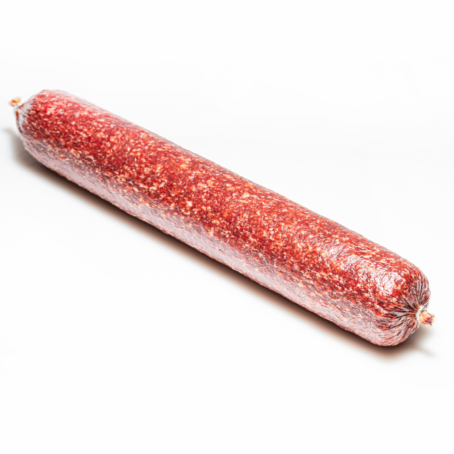 Hauseigene Salami in groß vor weißem Hintergrund.