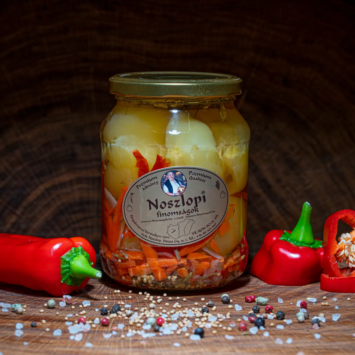 Noszlopi ungarisches Apfelpaprika in mild im Glas mit Paprika Deko auf Holzbrett.